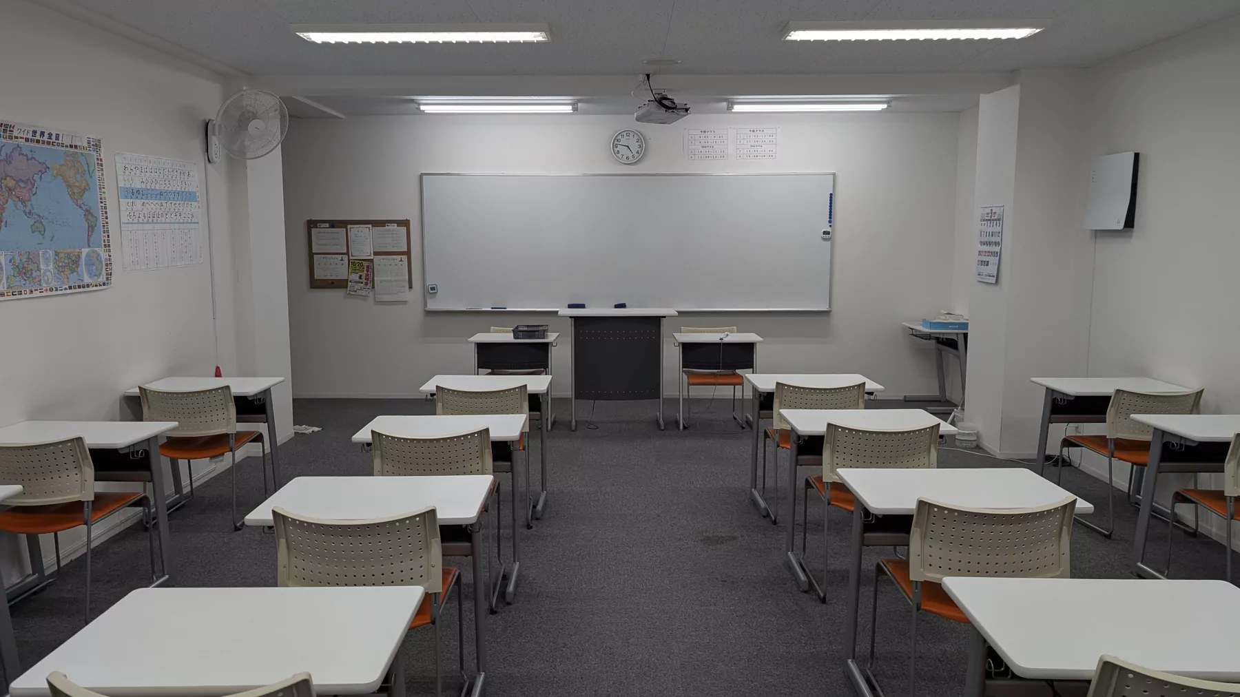 アース外語学院の教室（ホワイトボードと机が並ぶ室内）